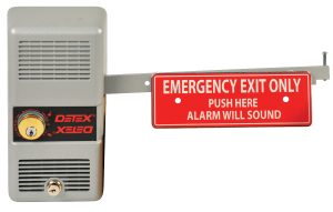 Wall-mounted emergency exit alarm with a red sign saying 'PUSH HERE ALARM WILL SOUND'.
