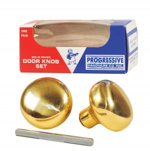 Solid brass door knob set with two knobs and a spindle displayed in front of its packaging.
