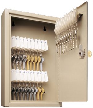 An open key storage cabinet with numbered key tags and hooks.