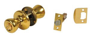A brass doorknob with internal mechanism, alongside its latch and strike plate.