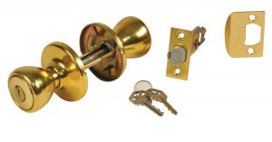 Gold-colored door knob with keys and lock components on white background.