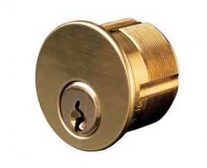 A golden cylindrical door lock cylinder isolated on a white background.