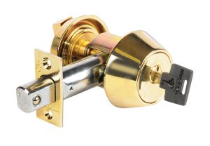 A gold-colored door knob with a key inserted, against a white background.