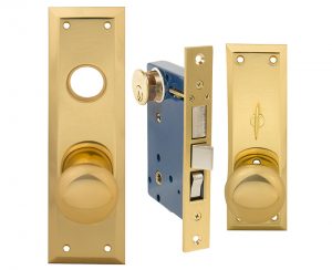 Brass door handle, lock, and keyhole on separate plates isolated on a white background.