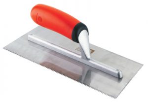 A notched trowel with a red and black handle on a white background.