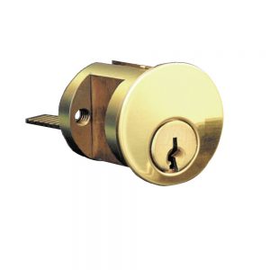 A brass cylinder lock with a key inserted on a white background.