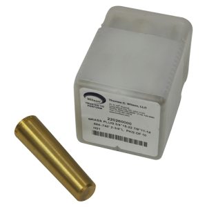 A brass cylindrical object next to its packaging with a label.