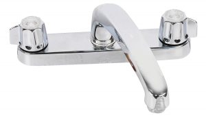 Chrome two-knob wall-mounted faucet isolated on a white background.