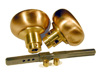 Two brass doorknobs and a matching spindle on a white background.