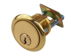 Gold door knob with keyhole and mounting screws on white background.