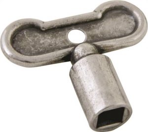 A metal wind-up key, possibly from a vintage toy or mechanical device, on a white background.
