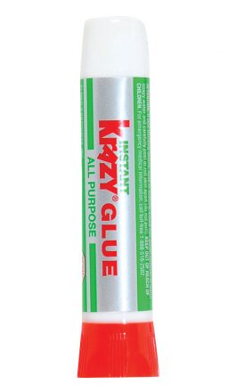 Tube of adhesive with a red cap and green label on a white background.