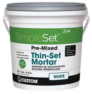 A white bucket of SimpleSet pre-mixed thin-set mortar for tiling.