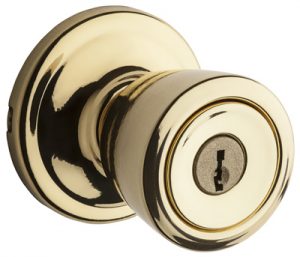 Polished brass door knob with keyhole, isolated on a white background.