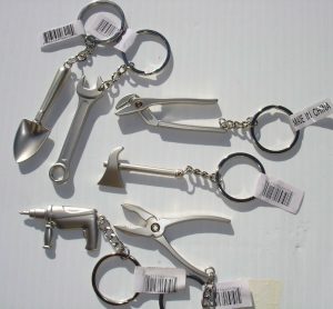 Keychains shaped like tools laid out on a white surface.