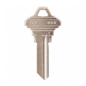 A standard metal house key isolated on a white background.