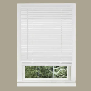 White blinds partially covering a window with a view of green trees.