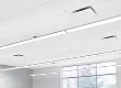 Modern office interior with large windows and linear ceiling lights.