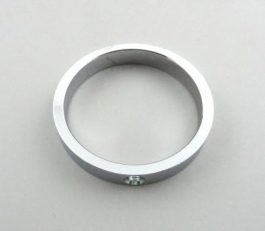 A simple silver metal ring with a flat edge and a small screw on a plain background.