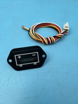 A black plastic electric component with a multicolor wire harness on a blue surface.