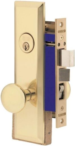 Gold-colored door handle with keyhole and latch mechanism on wooden frame.