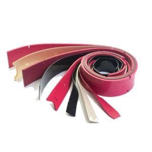 A variety of colored leather belts coiled and stacked on a white background.